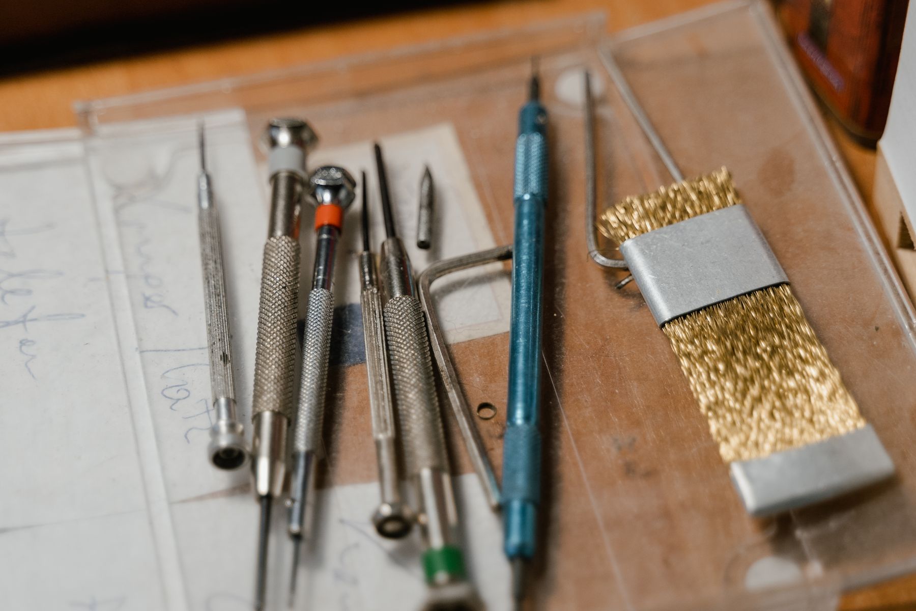 Precision watchmaking tools arranged in a clear workbench tray